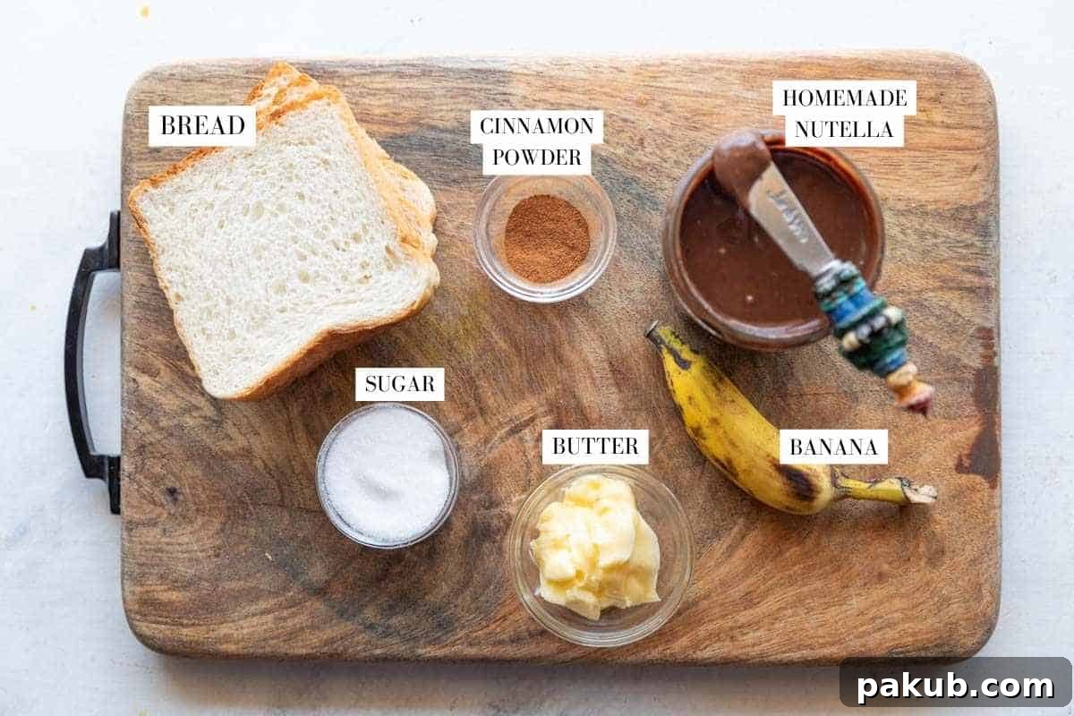 Ingredients for a chocolate banana sandwich laid out on a table, including bread, Nutella, bananas, butter, sugar, and cinnamon.