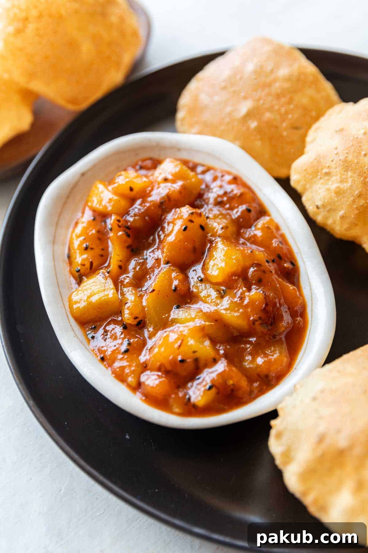 Tangy Green Mango Relish 4 raw mango chutney in a white bowl served with hot pooris