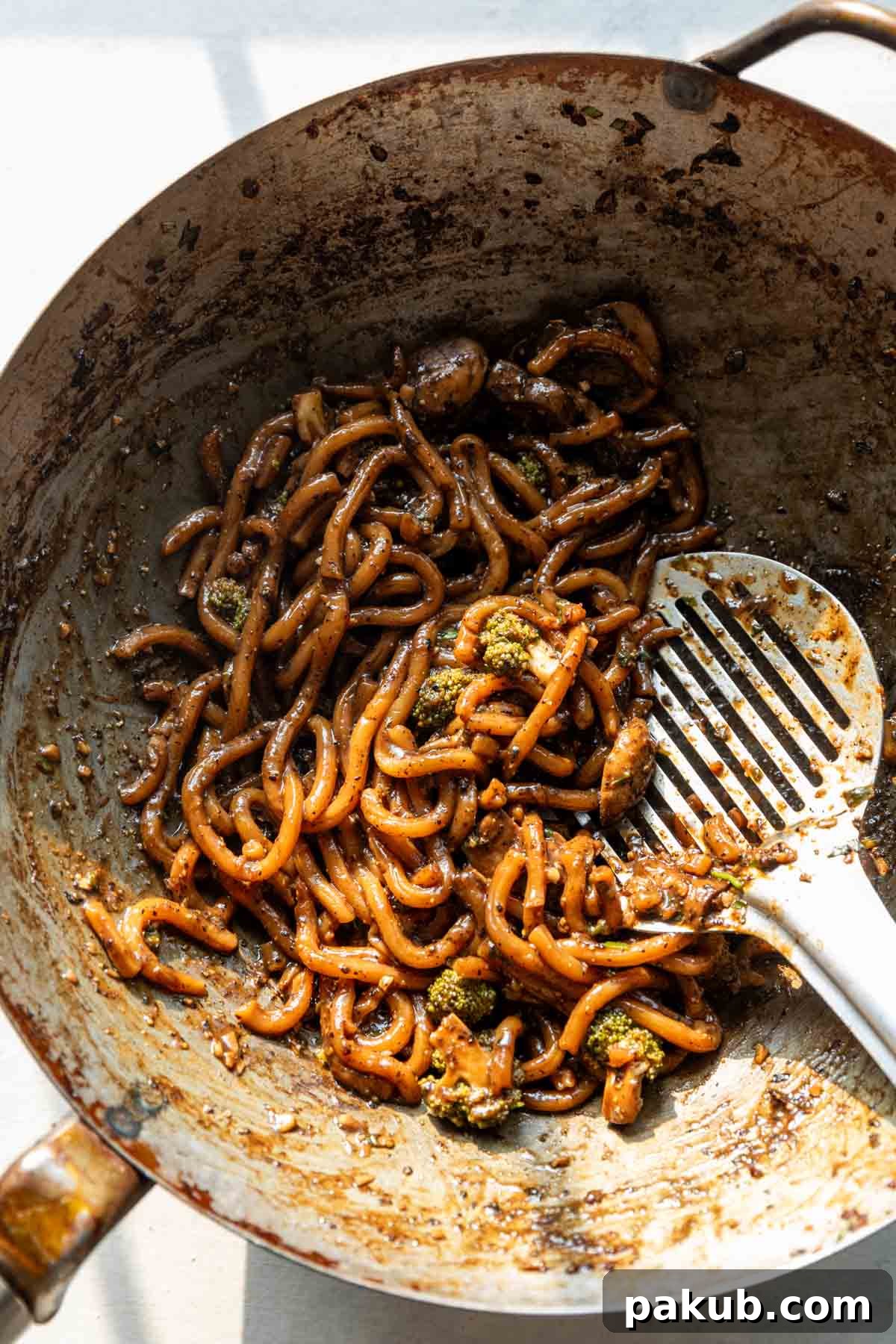 Peppered Udon Noodles 4 The finished Black Pepper Udon Noodles, freshly tossed in a large wok, showcasing the perfect coating of dark, glossy sauce on the thick noodles and tender-crisp vegetables, ready to be served.
