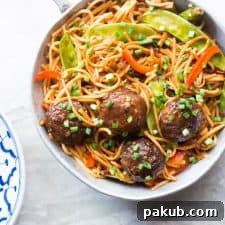 One Pan Veg Noodle and Manchurian Stir Fry served in a pan, showcasing a harmonious blend of saucy noodles and Manchurian balls.