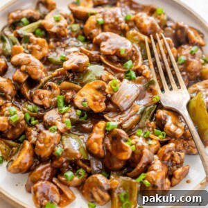Crispy Air Fryer Mushroom Chilli served on a white plate with a fork, ready to be devoured.