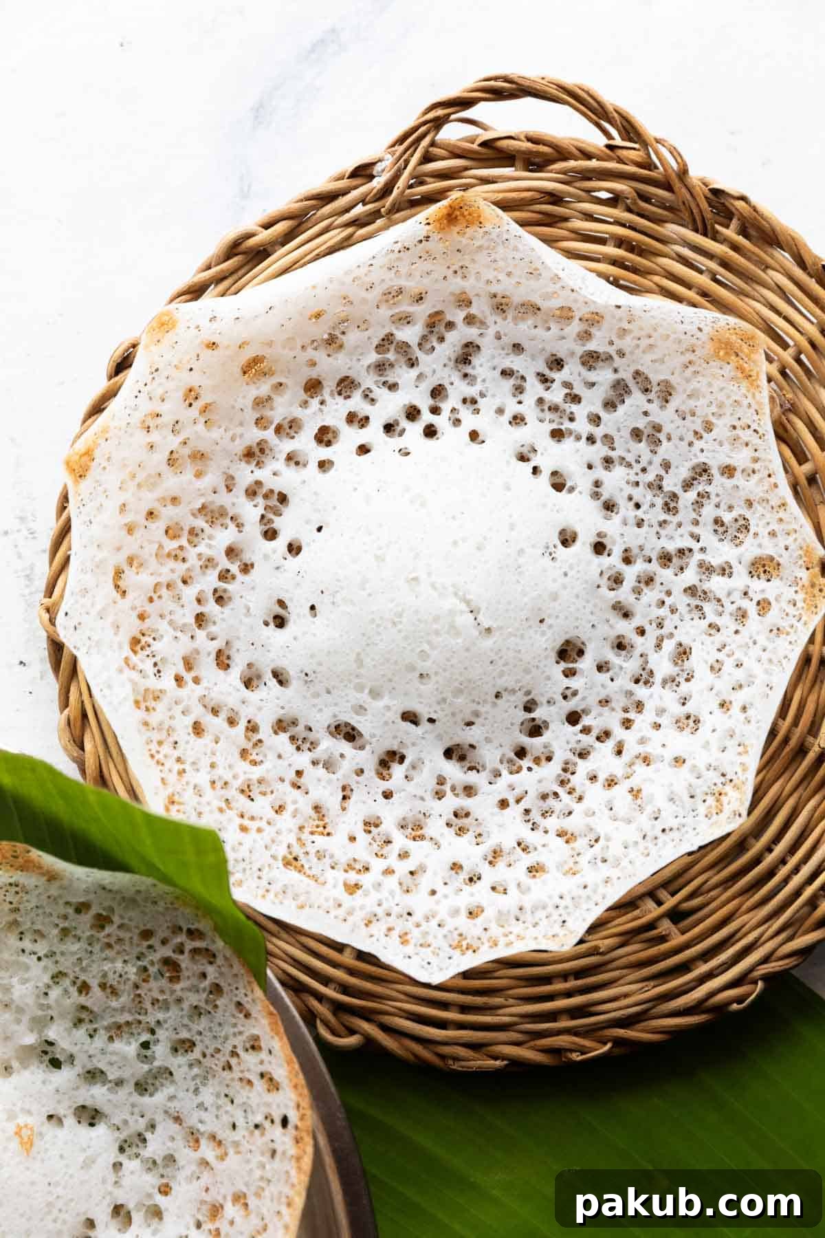 Velvety Tender Coconut Palappam 3 Tender coconut appam in a wicker basket