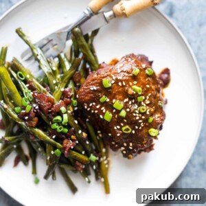Spicy Korean Chicken Thighs in Gochujang Sauce, served on a pristine white plate, showcasing their crispy edges and rich glaze.