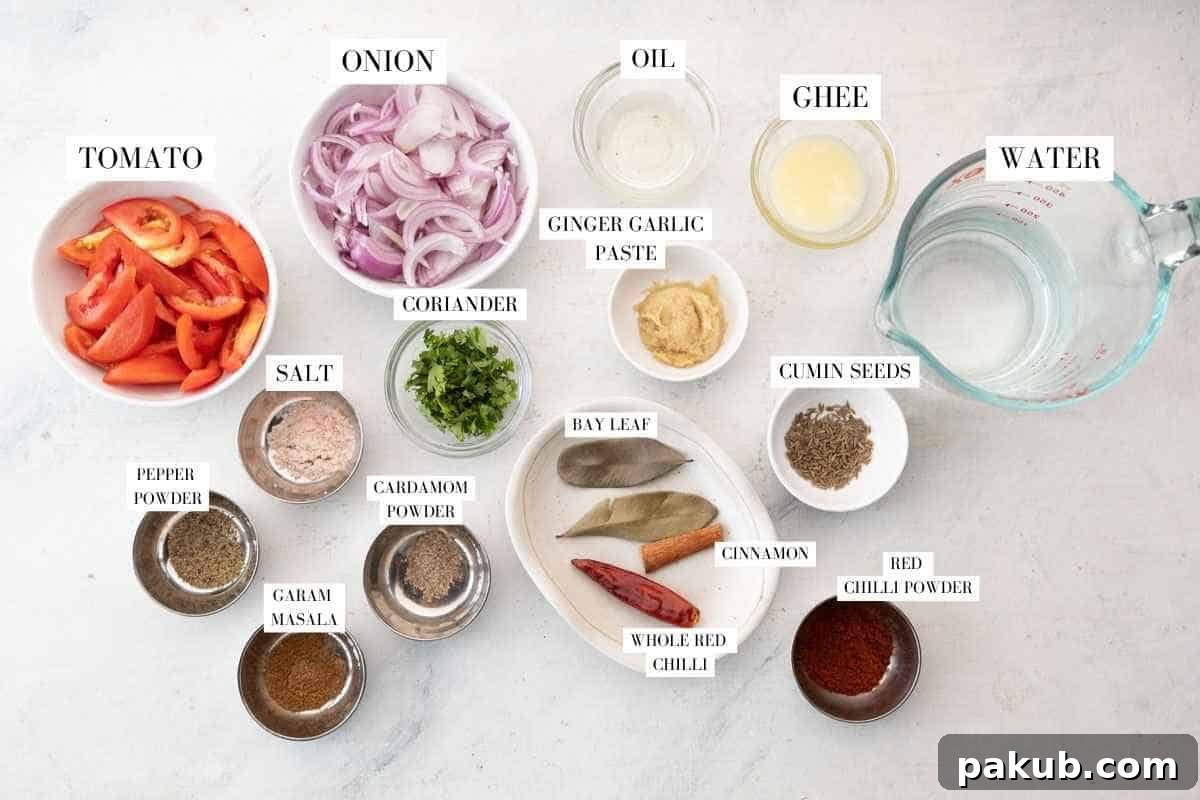 A colorful array of ingredients for the pressure cooker chicken curry gravy, including sliced onions, chopped tomatoes, ginger, garlic, and whole spices like cumin seeds, bay leaves, cinnamon stick, and red chilies.