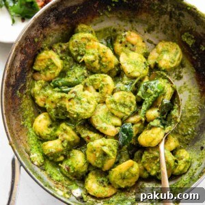 Curry leaf prawns in a frying pan with spoon