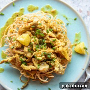 Lemon Chicken served on a bed of fried noodles on a blue plate with fork