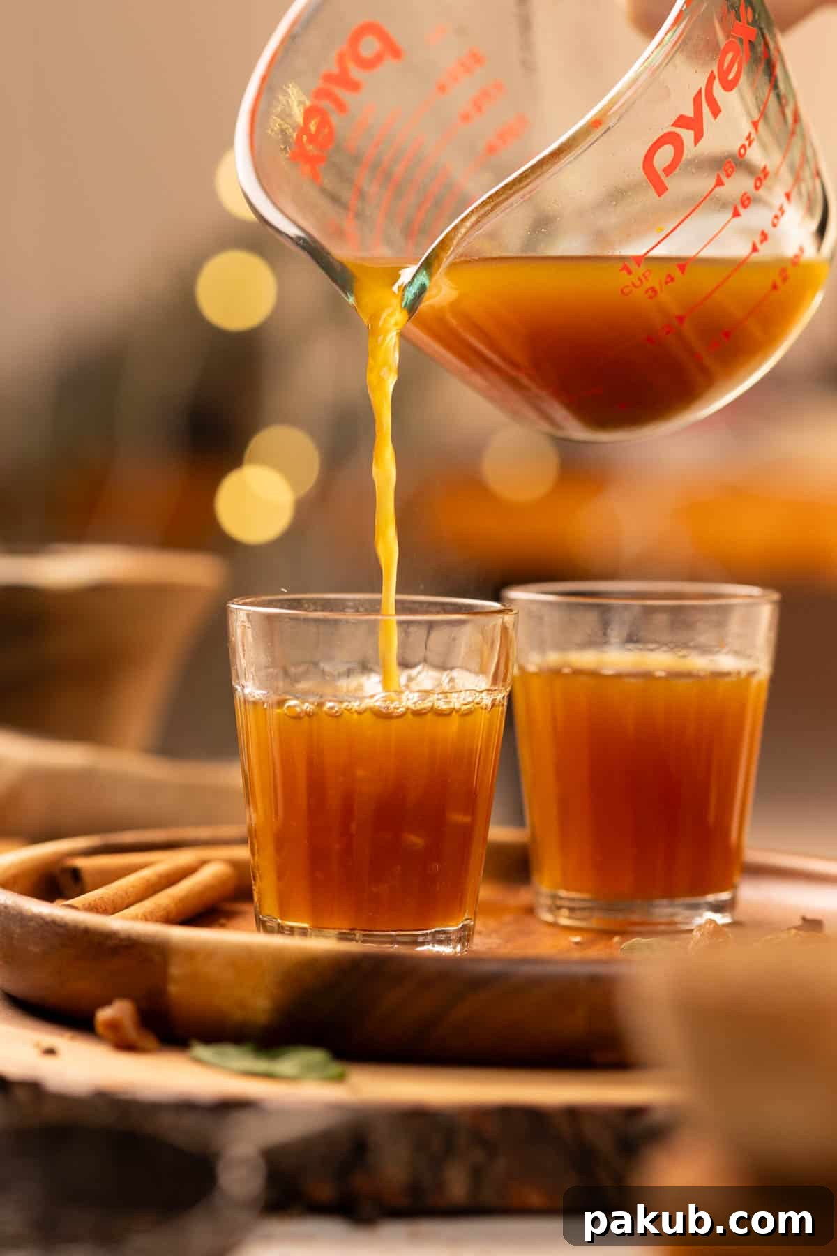 pouring piping hot kadha into glasses, steam rising