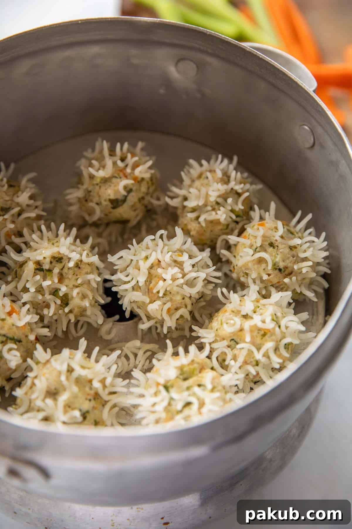 Close-up of Chicken Porcupine Meatballs neatly arranged in a steamer basket, highlighting their unique rice-coated surface before cooking