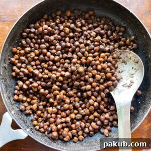 Kala Chana, or dried black chickpeas, perfectly cooked and presented in the traditional iron pan it was prepared in.