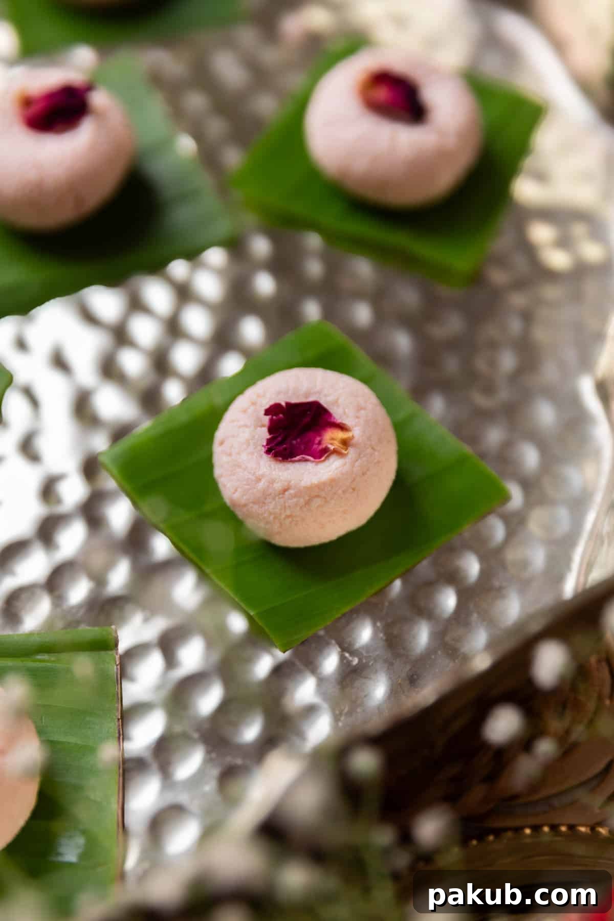 Rose Kissed Paneer Truffles 2 Rose Kacha Golla garnished with dried rose petals and served beautifully on a small leaf square