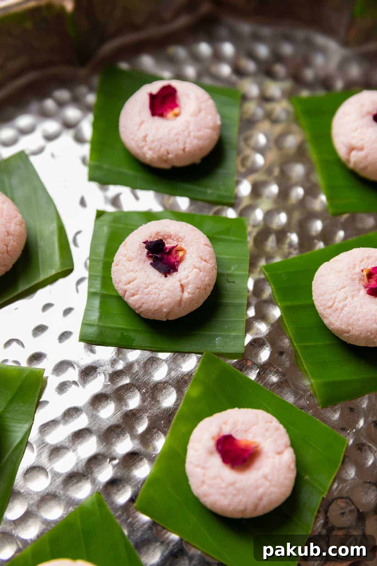 Rose Kissed Paneer Truffles 3 Two Rose Kacha Gollas with dried rose petals, served on a banana leaf square, ready to be devoured