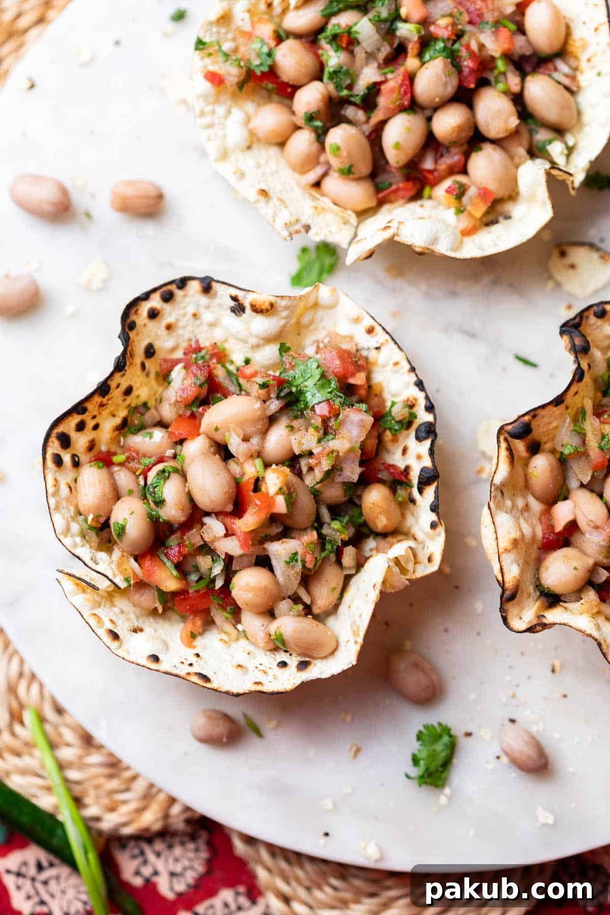 Crispy Papad Chaat Bowl 2 Crispy, edible papad bowls brimming with vibrant masala peanut chaat, artfully arranged on a pristine white platter, perfect for a festive occasion.