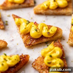 close up of rasmalai sandwich garnished with pistachios and served on a white platter