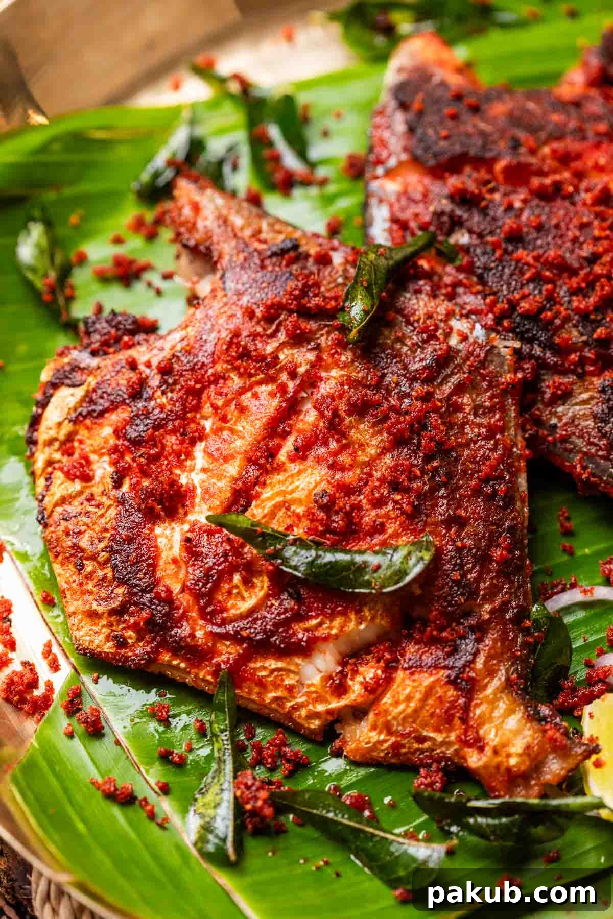 A close-up image of a perfectly fried Mangalorean Fish Fry, showcasing its crispy texture and vibrant spice coating.