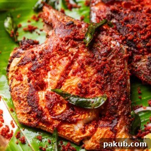 A close-up image of a perfectly fried Mangalorean Fish Fry, showcasing its crispy texture and vibrant spice coating.