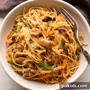 Easy Chicken Chow Mein, perfectly cooked and served in a white bowl with a fork on the side