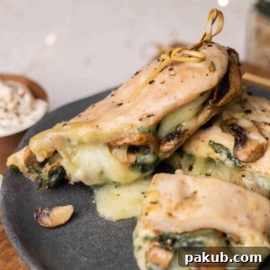 Spinach Mushroom Stuffed Chicken Breast, beautifully plated on a grey dish, showcasing its elegant presentation
