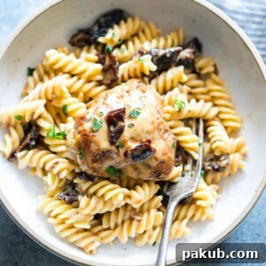 Creamy Sun-dried Tomato Chicken served alongside pasta in a bowl, showcasing the rich sauce and tender chicken