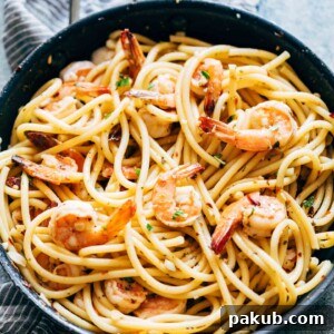 Shrimp Spaghetti Aglio Olio, delicately garnished with fresh parsley and Parmesan cheese, served beautifully in a bowl