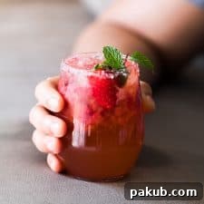 A vibrant Mint Strawberry Moscow Mule Cocktail, garnished with fresh mint and a glistening salt rim, served in a stylish glass
