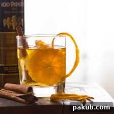 An enticing Orange Cinnamon Whisky Smash served with elegant orange peels in a glass, ready to be enjoyed