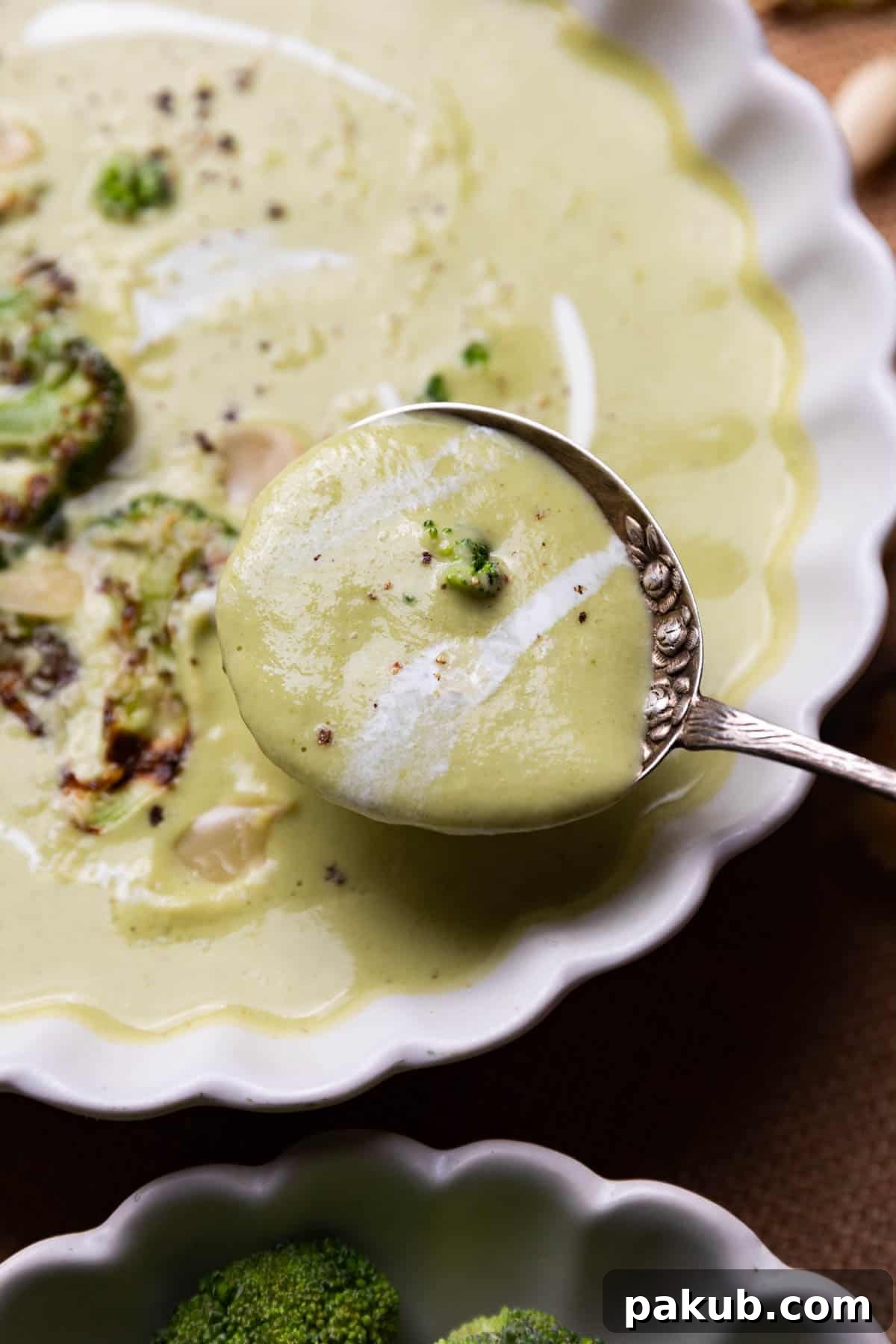 A close-up view of the creamy broccoli almond soup, showcasing its smooth, thick texture and vibrant green color.