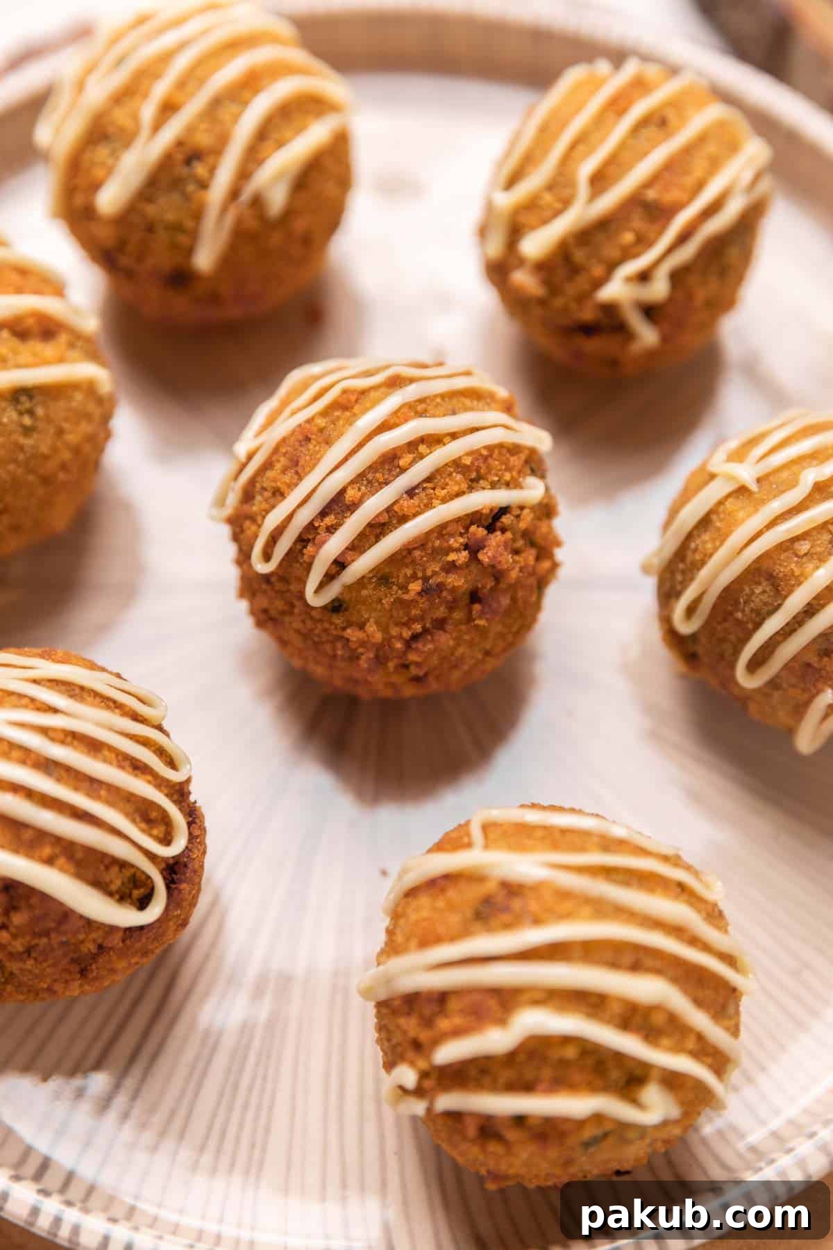 Golden brown chicken curry rice balls with a crispy exterior and a hint of a cheesy center, artfully arranged on a platter, ready to be served as an appetizer.