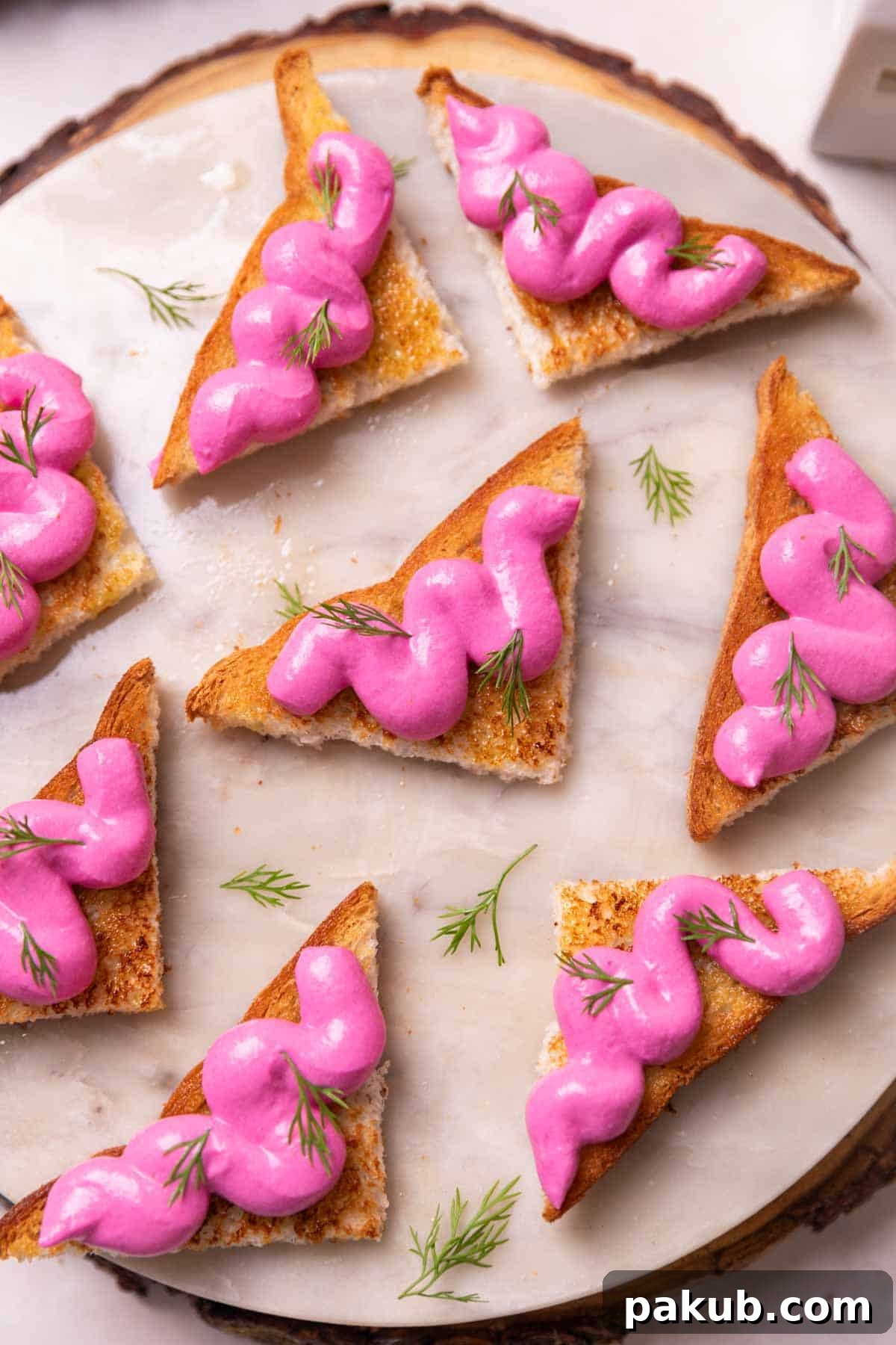 An inviting image of several vibrant paneer beetroot toasts, garnished and served on a elegant round white platter, ready to be enjoyed as a perfect party appetizer.