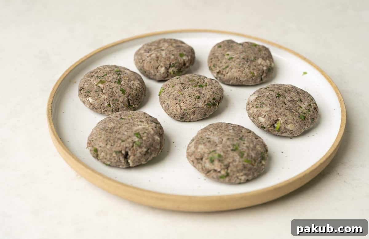 Raw banana tikki or kachhe kele ke kebab perfectly shaped and placed on a pristine white plate, showcasing their inviting appearance.