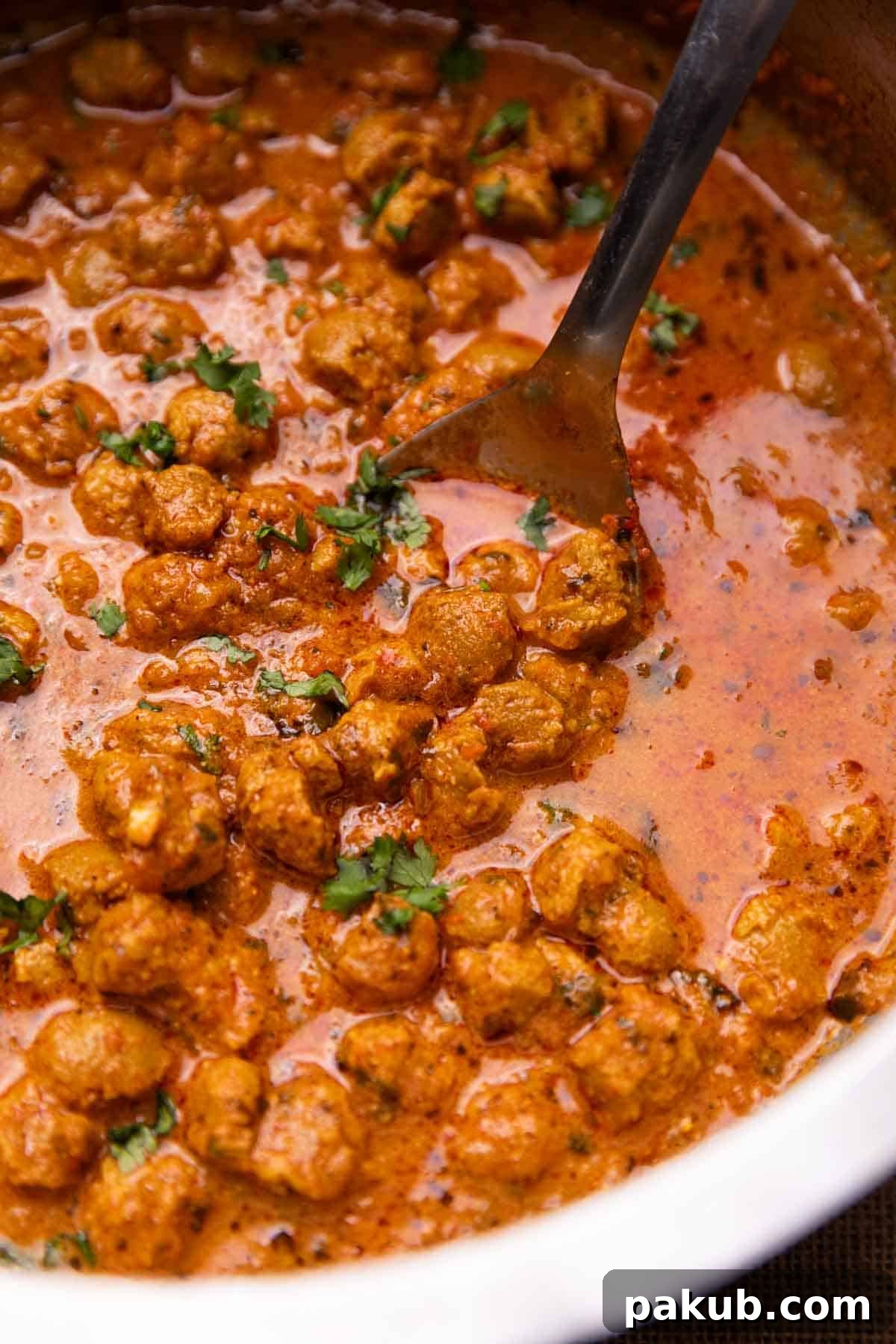 Savory Soya Nugget Curry 3 A simmering pot of rich soya curry in a traditional Indian kadai, with a ladle resting inside, showcasing its mouth-watering texture.