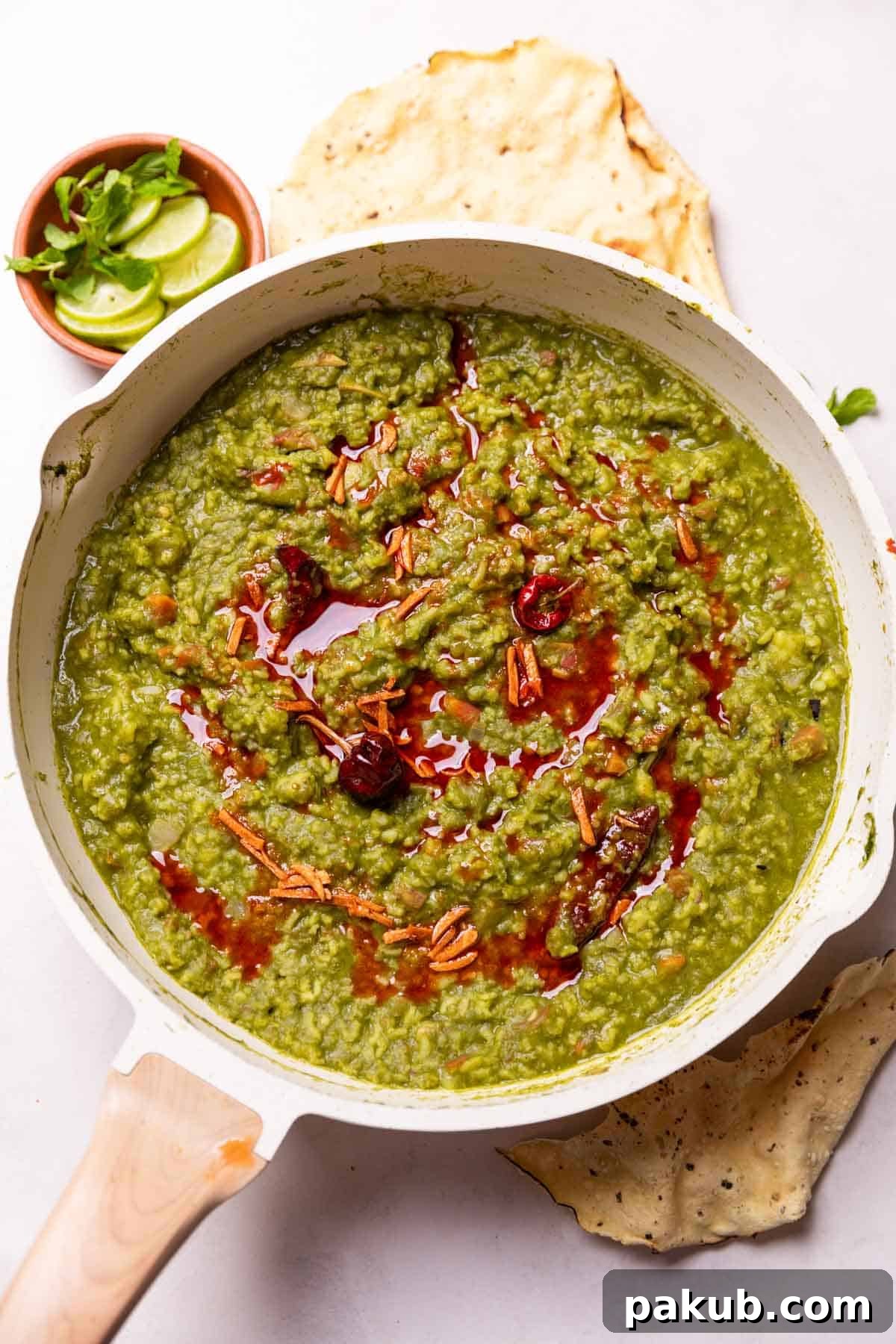 A vibrant bowl of Palak Khichdi with accompaniments like yogurt, pickle, and papad, inviting you to dig in.