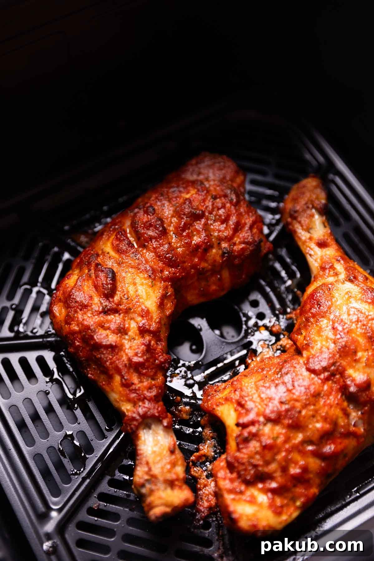 Crispy Air Fried Tandoori Chicken 4 Close-up shot of tandoori chicken cooking inside an air fryer basket, showing a beautiful char and vibrant color.