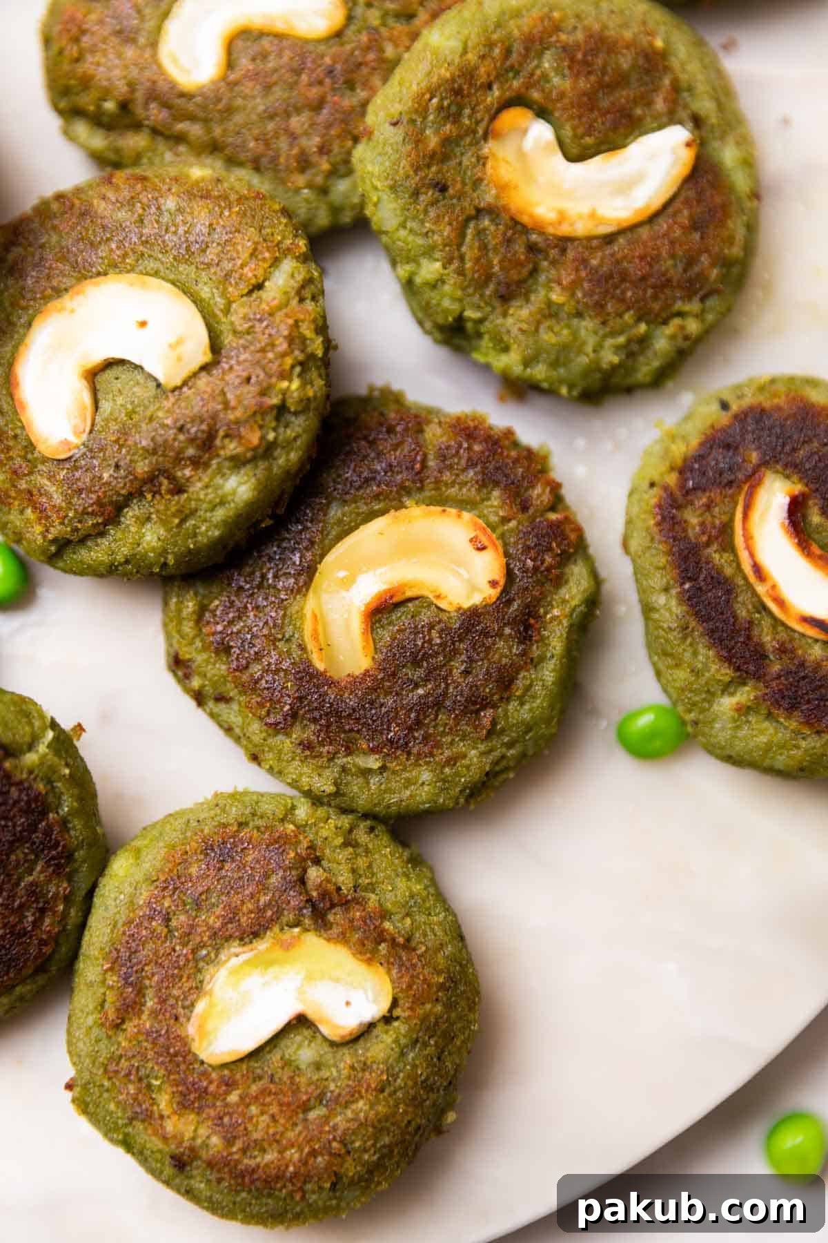 Emerald Vegetable Kebab 3 A close-up shot of crispy Hara Bhara Kebabs, showcasing their golden-brown exterior, soft green interior, and a perfectly placed cashew garnish.