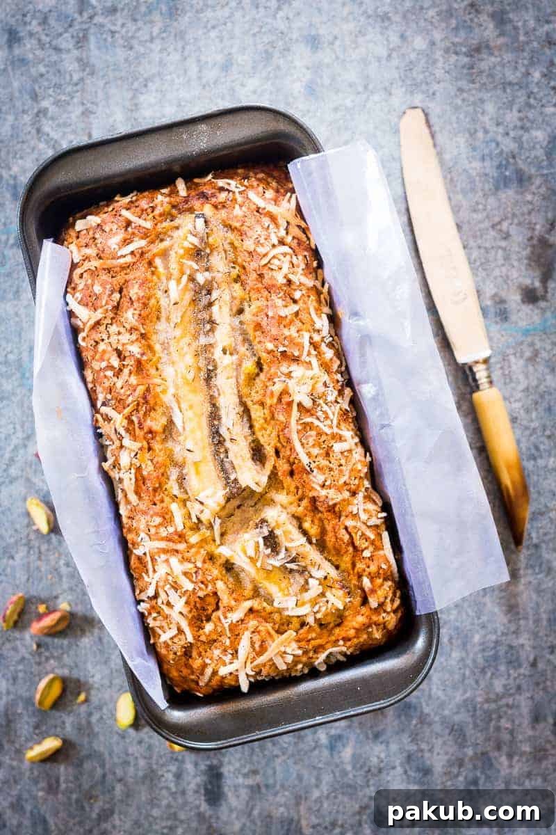 Quick Coconut Pistachio Banana Bread A beautifully sliced loaf of Quick Coconut Pistachio Banana Bread, showcasing its moist texture, vibrant pistachios, and shredded coconut. Perfect for a healthy and quick snack or holiday treat.