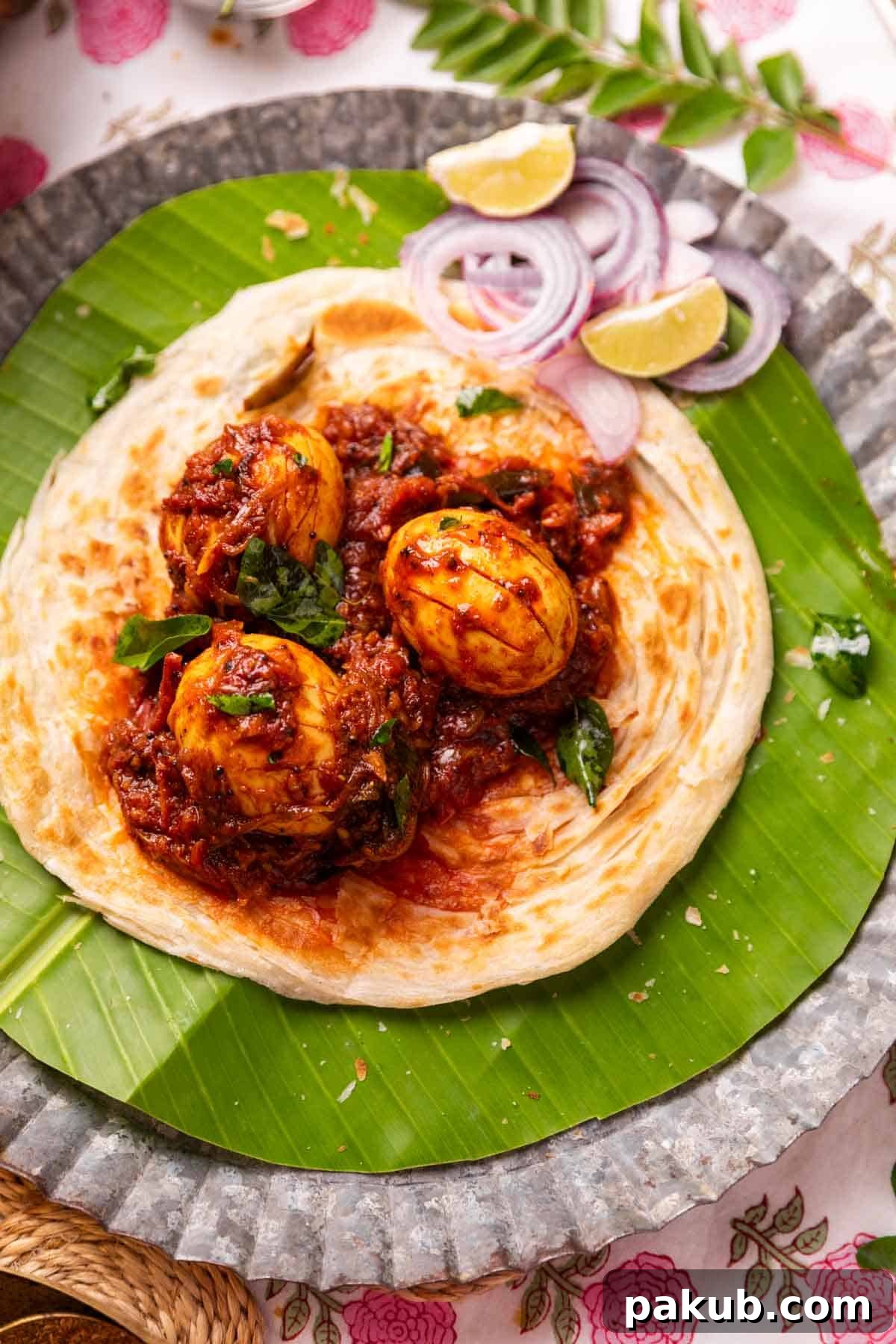 Authentic Kerala Egg Roast 2 Kerala egg roast served on Malabar Parotta with accompaniments, showcasing its vibrant color and rich texture.