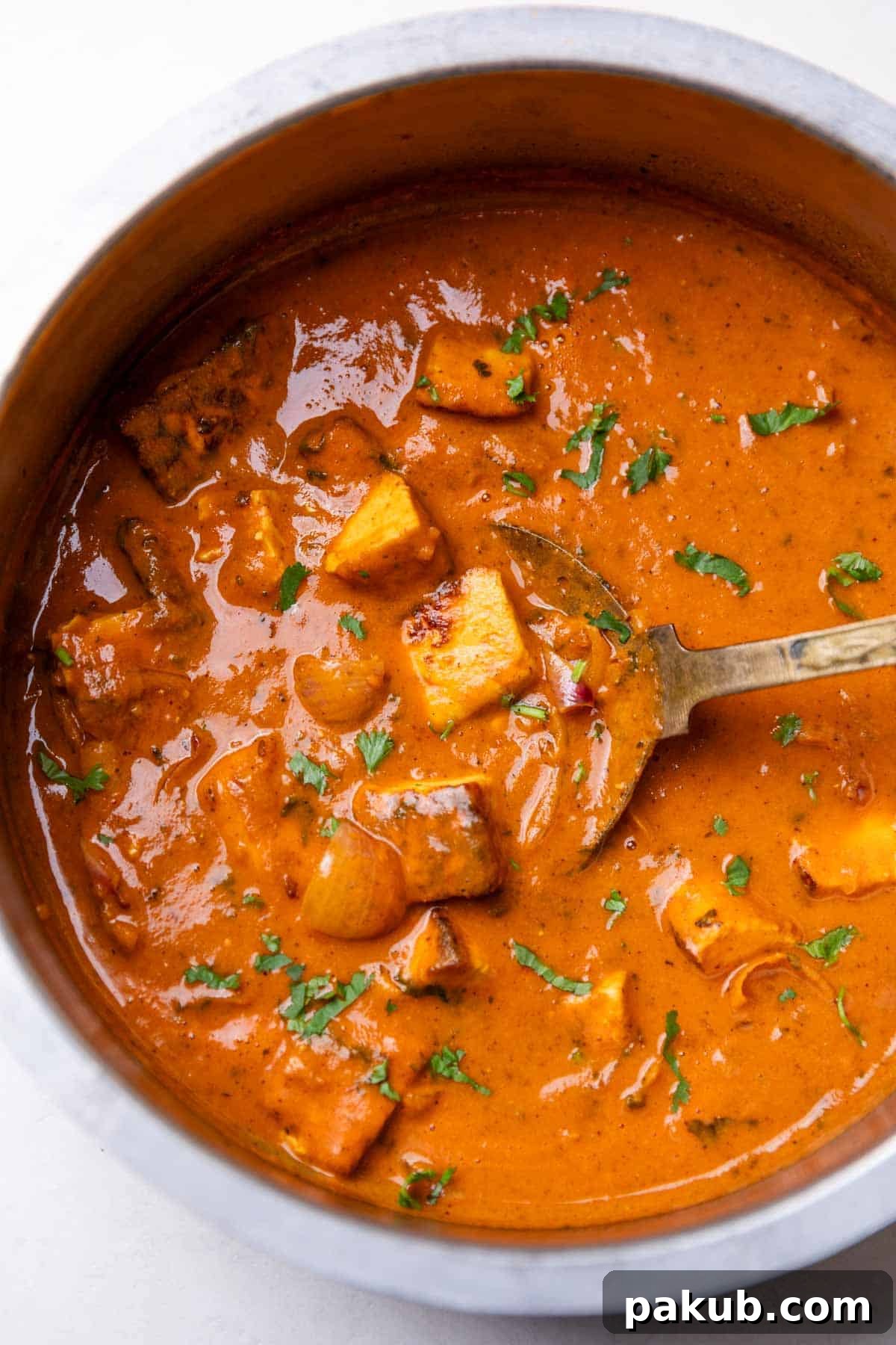 Freshly made paneer do pyaza served in a traditional Indian kadai, garnished with fresh cilantro.