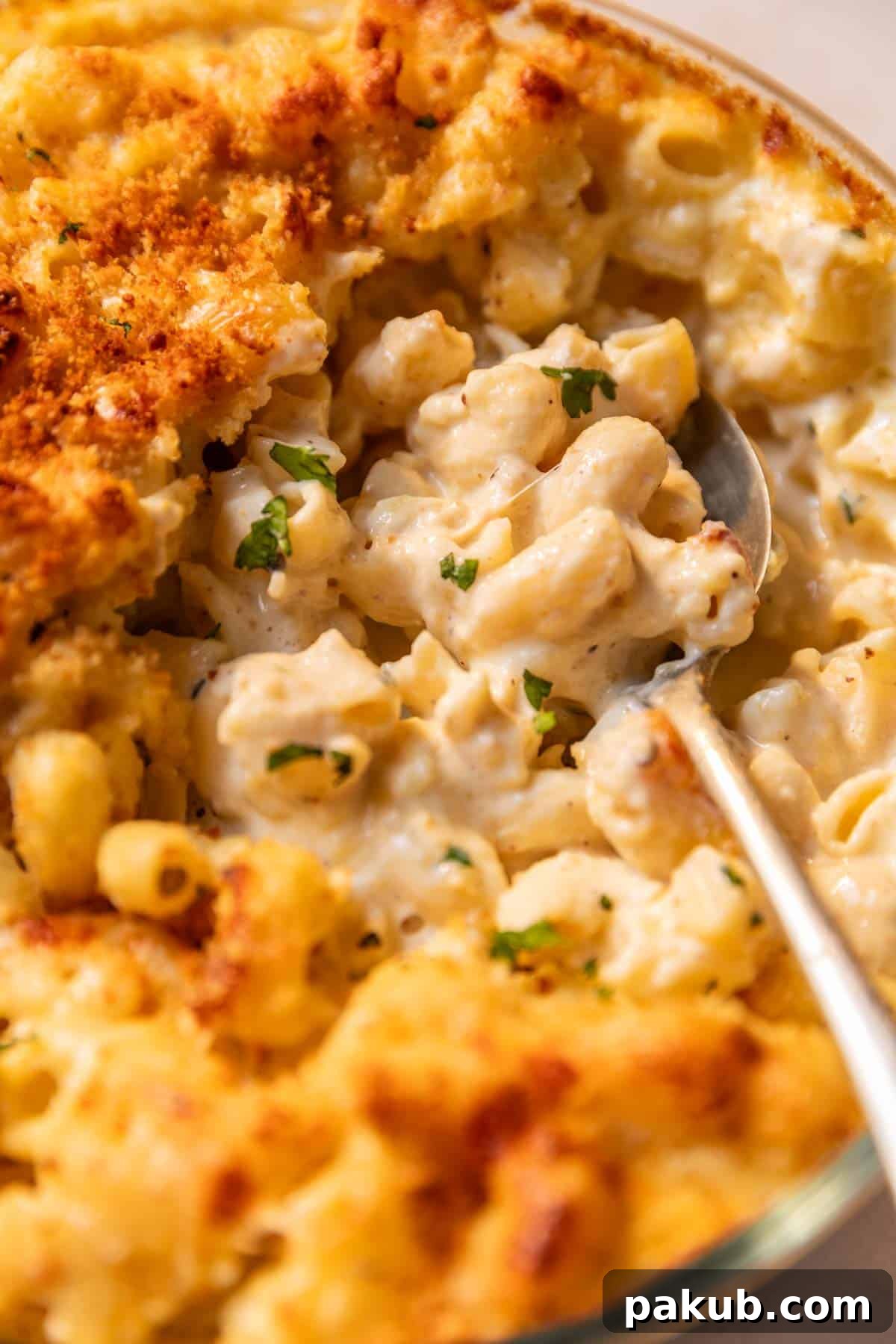 Close-up of a serving of air fryer mac and cheese in a bowl, showing the creamy texture and golden-brown topping.