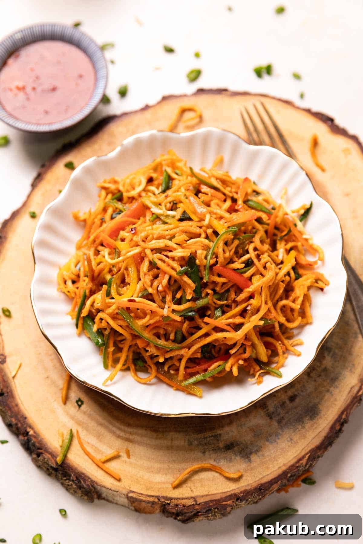 Indo-Chinese Street Crunch 2 A vibrant bowl of Chinese Bhel, showcasing crispy noodles, fresh vegetables, and a glossy sauce, ready to be enjoyed.