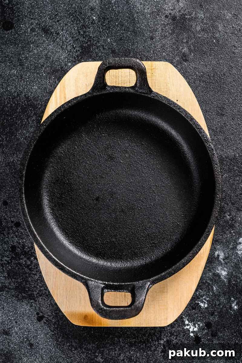 a freshly cleaned and seasoned cast iron pan on a wooden board