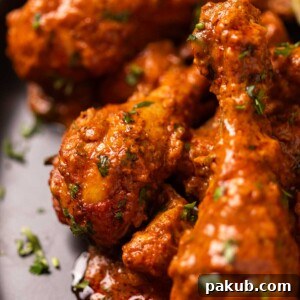 Chicken Handi served on a black plate, garnished with fresh coriander.