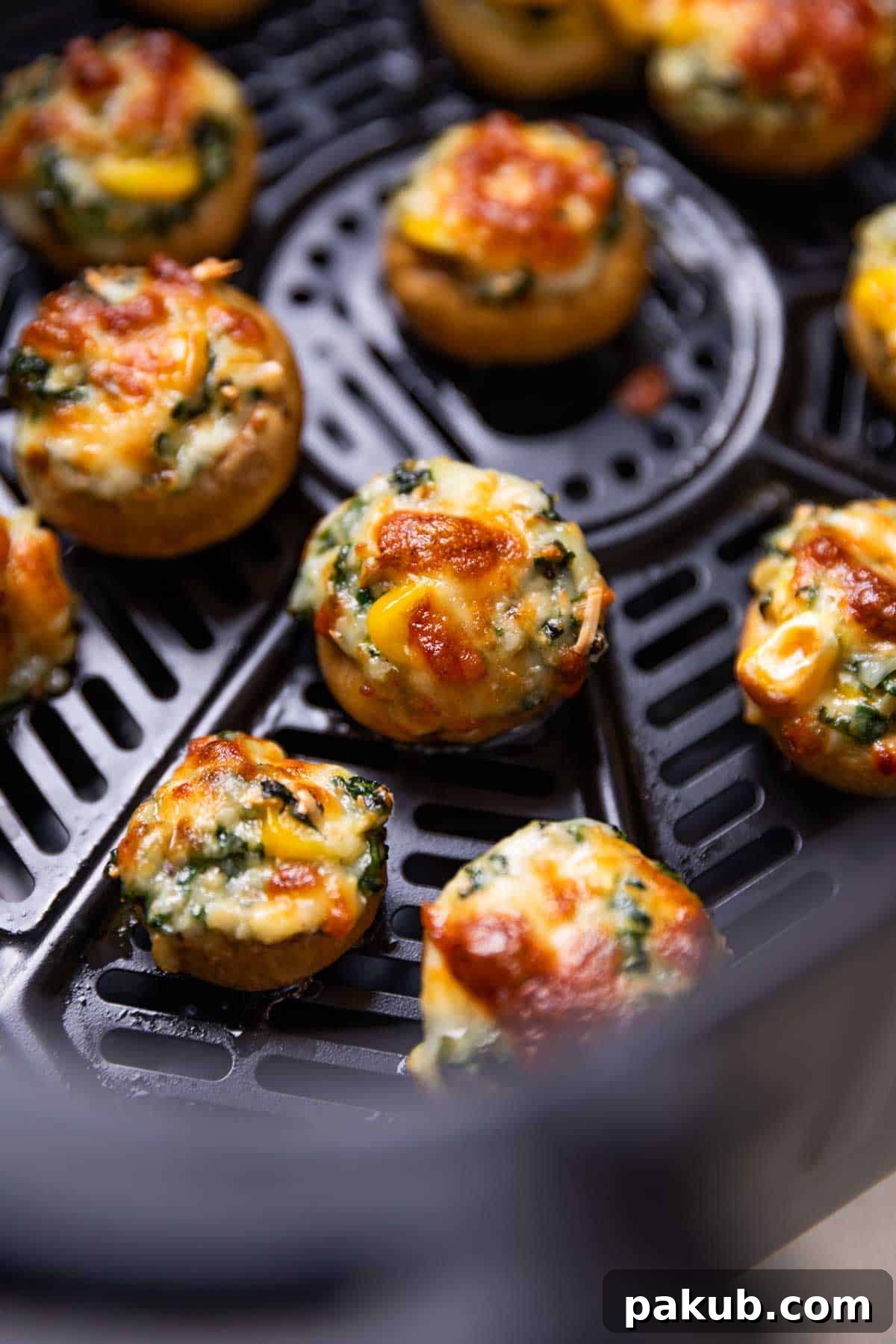 freshly baked air fryer stuffed mushroom lined up in the air fryer, showcasing versatility