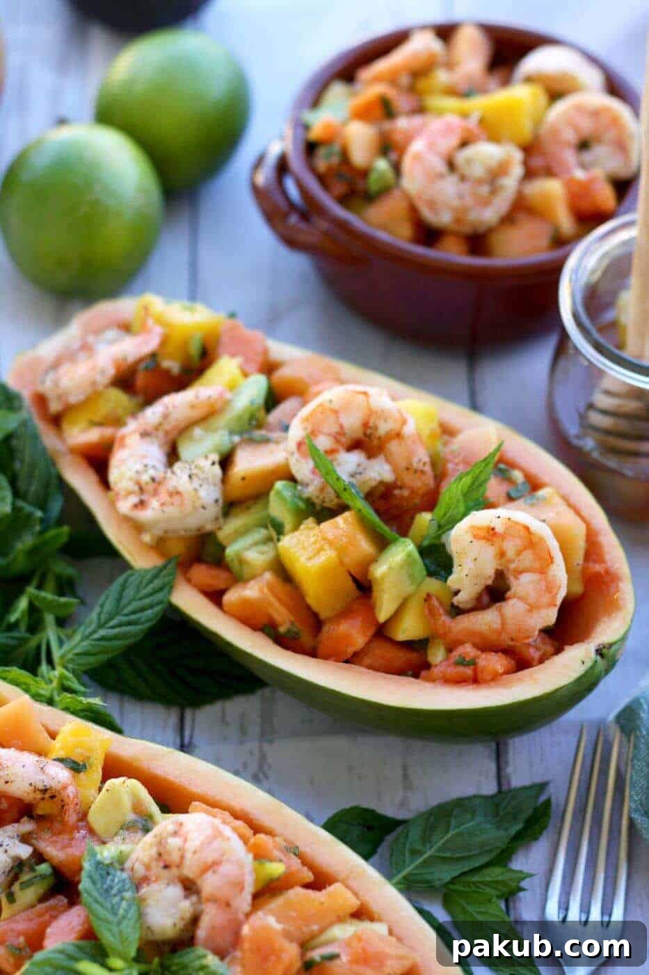 A collection of 13 insanely delicious savoury mango recipes that are sure to blow your mind if you've always had mangoes in sweet dishes. These recipes combine the juicy sweetness of mangoes with savoury ingredients to create a dish that's truly stellar and unforgettable! #spring #mango #recipes #easter #summer #fruit An exotic Papaya Prawn Mango Salad elegantly served within hollowed-out papaya boats, offering a stunning presentation and delightful taste.