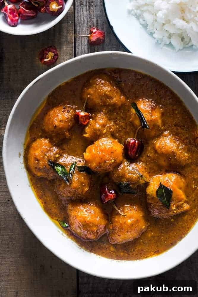 A collection of 13 insanely delicious savoury mango recipes that are sure to blow your mind if you've always had mangoes in sweet dishes. These recipes combine the juicy sweetness of mangoes with savoury ingredients to create a dish that's truly stellar and unforgettable! #spring #mango #recipes #easter #summer #fruit A generous serving of rich Ripe Mango Curry presented in a large white bowl, perfectly accompanied by a side of fluffy white rice, ready to be enjoyed.