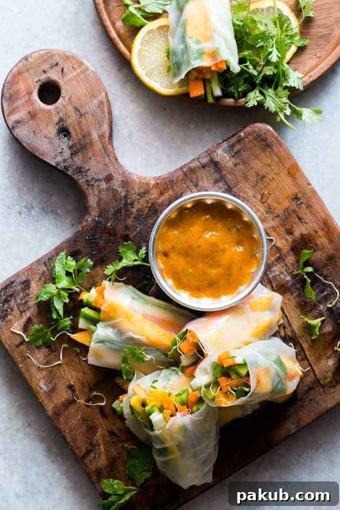 A collection of 13 insanely delicious savoury mango recipes that are sure to blow your mind if you've always had mangoes in sweet dishes. These recipes combine the juicy sweetness of mangoes with savoury ingredients to create a dish that's truly stellar and unforgettable! #mango #recipes #summer #spring #appetizers #easter An enticing arrangement of fresh mango bell pepper spring rolls, beautifully presented on a rustic wooden board, perfect for a savoury mango recipes roundup.