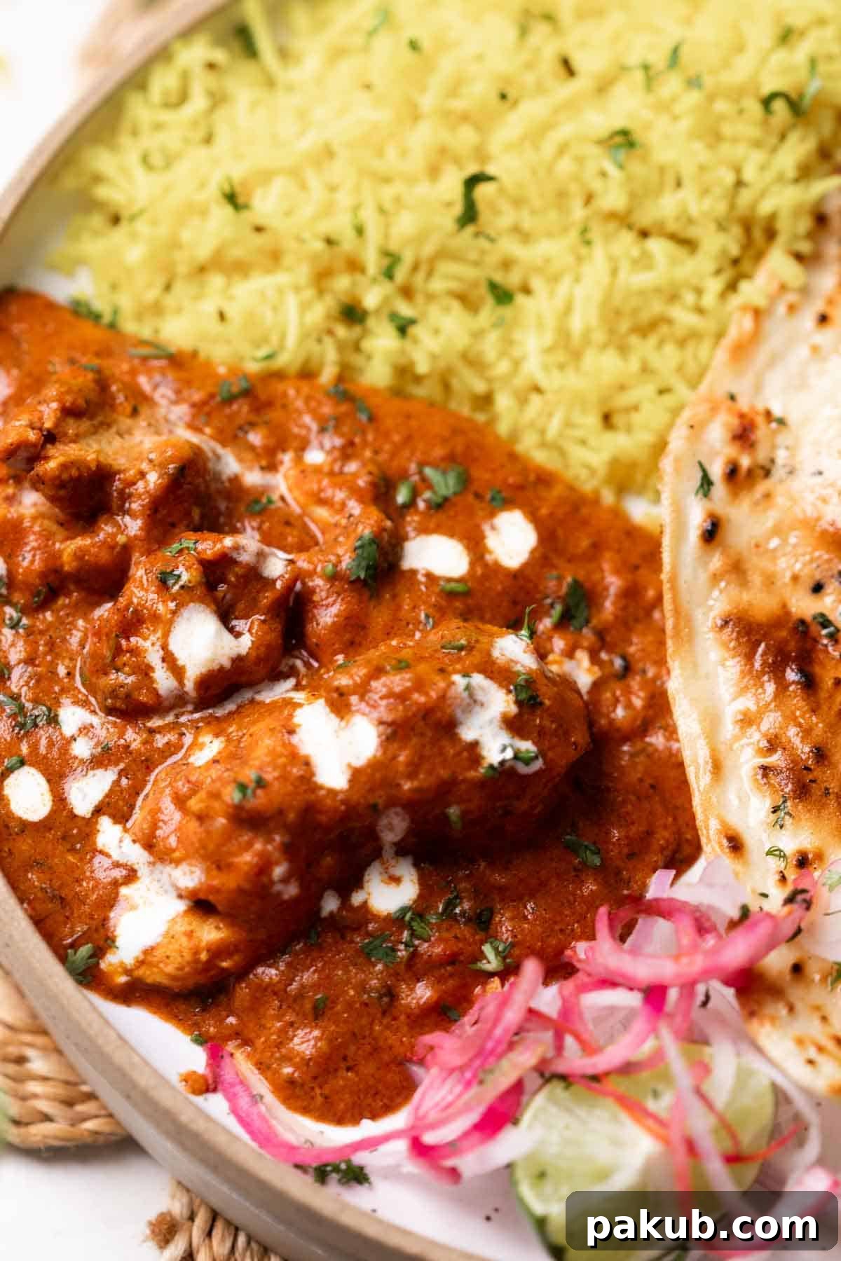 A vibrant and inviting plate of butter chicken with garnishes, perfect for a cozy dinner