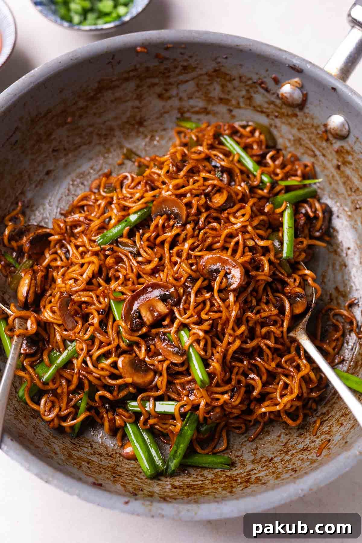 Forest Umami Ramen 3 Freshly cooked mushroom ramen noodles still in a hot pan, showing the rich sauce and perfectly coated ingredients.