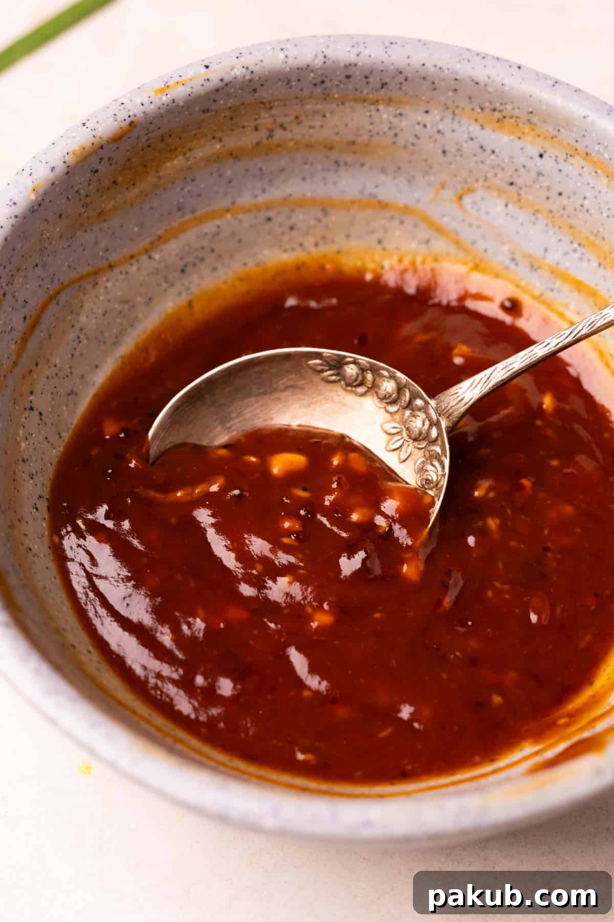 An image of the chilli chicken noodles sauce in a bowl with spoon