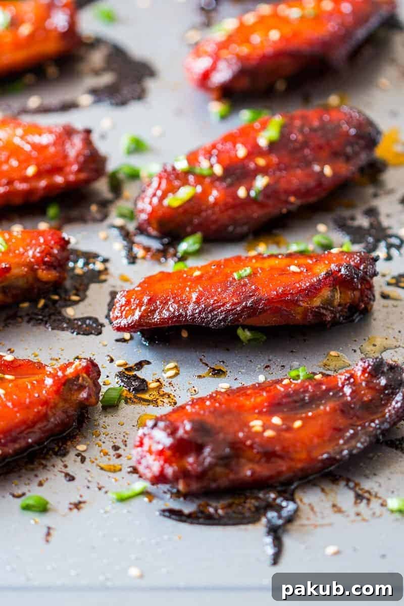 Platter of golden-brown Korean Baked Gochujang Chicken Wings garnished with sesame seeds.