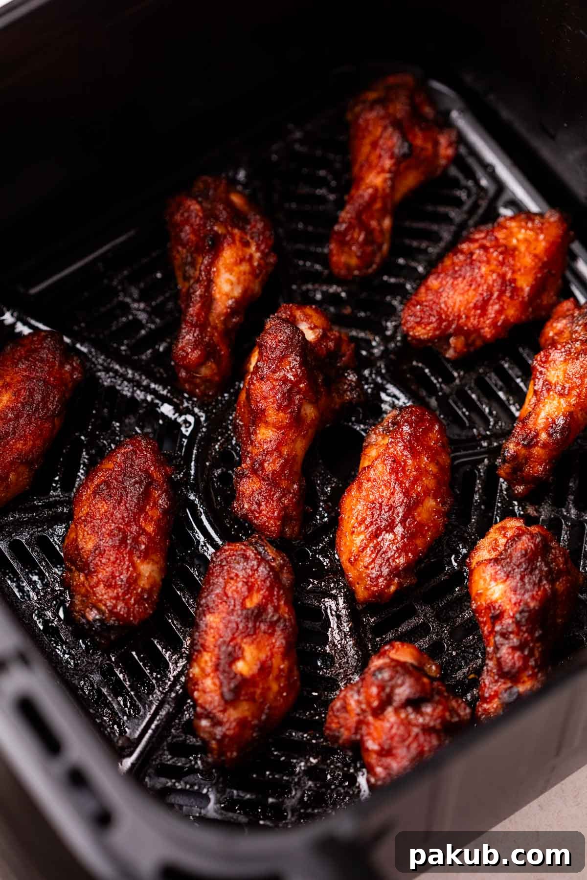 Fiery Air Fryer BBQ Chicken Wings 3 Air fryer basket filled with beautifully arranged, golden-brown Air Fryer Spicy BBQ Chicken Wings, showcasing their even crispiness.