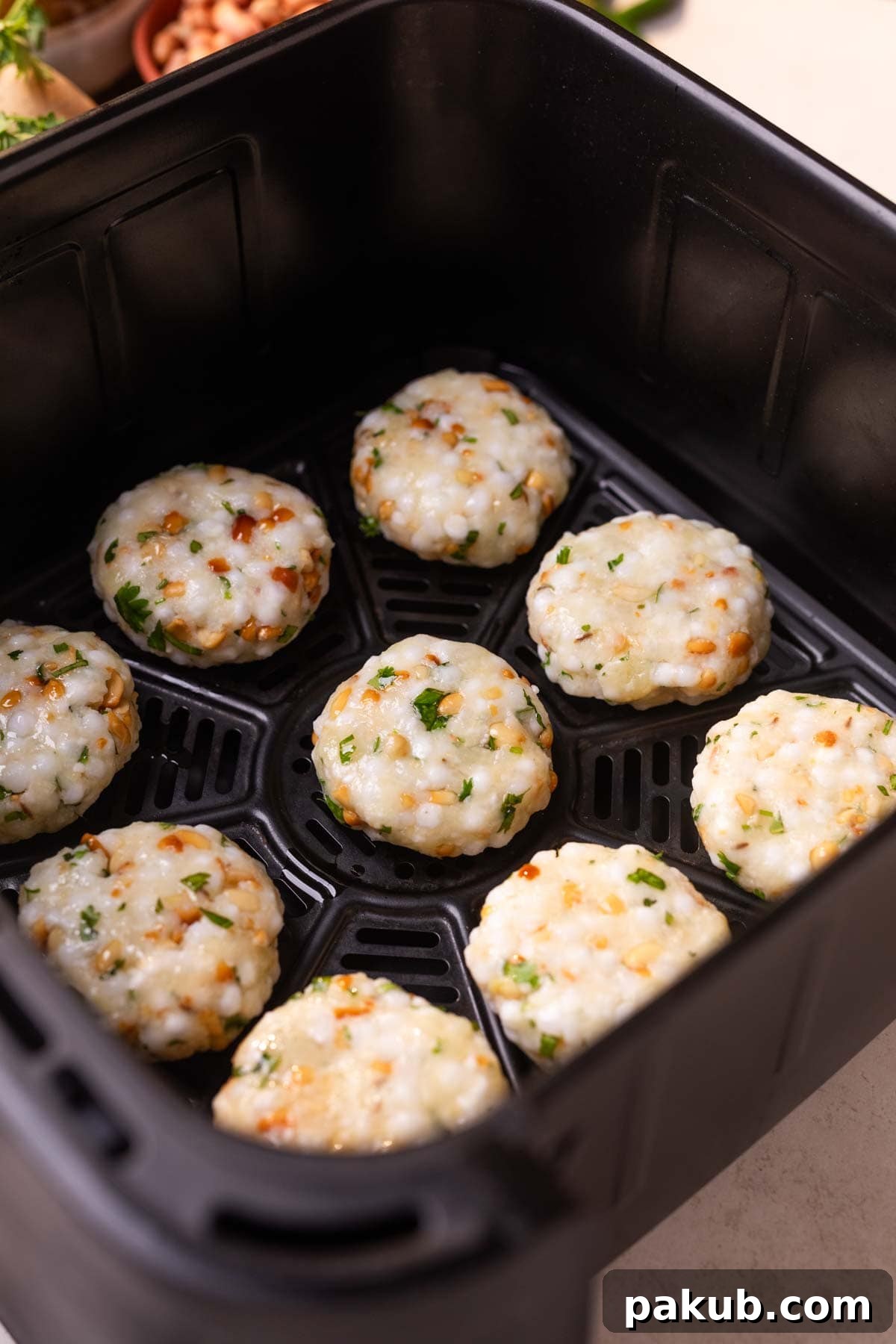 Crispy Air Fryer Sabudana Vada 4 An image of uncooked air fryer sabudana vadas placed in the air fryer ready to bake